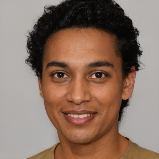 Joyful latino young-adult male with short  brown hair and brown eyes