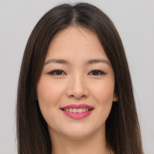 Joyful asian young-adult female with long  brown hair and brown eyes