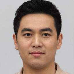 Joyful asian young-adult male with short  black hair and brown eyes