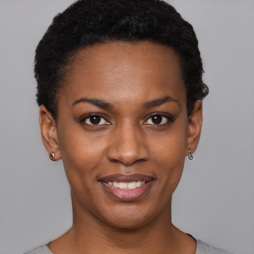 Joyful black young-adult female with short  black hair and brown eyes