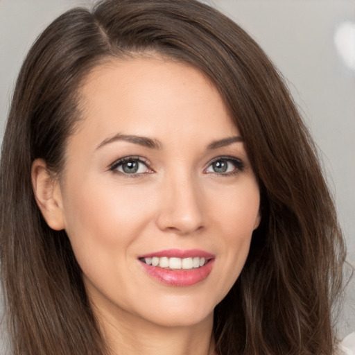 Joyful white young-adult female with long  brown hair and brown eyes