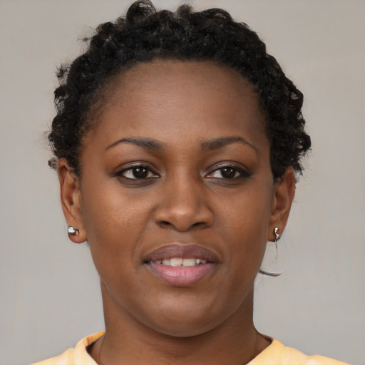 Joyful black young-adult female with short  brown hair and brown eyes
