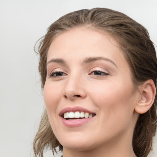 Joyful white young-adult female with medium  brown hair and grey eyes