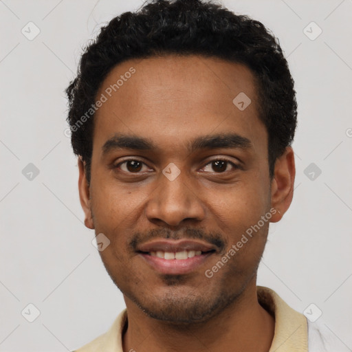 Joyful black young-adult male with short  black hair and brown eyes