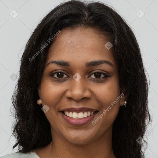 Joyful black young-adult female with long  brown hair and brown eyes