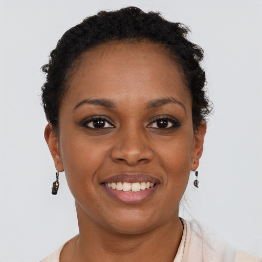 Joyful black young-adult female with short  black hair and brown eyes