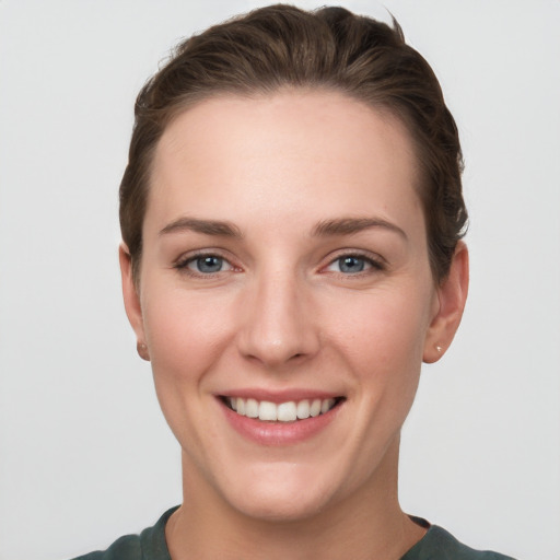 Joyful white young-adult female with short  brown hair and grey eyes