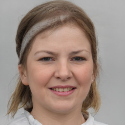 Joyful white young-adult female with medium  brown hair and blue eyes