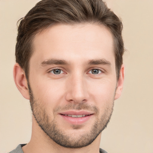 Joyful white young-adult male with short  brown hair and grey eyes