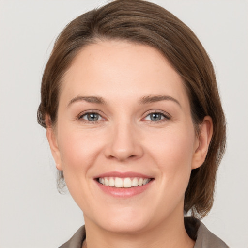 Joyful white young-adult female with medium  brown hair and grey eyes