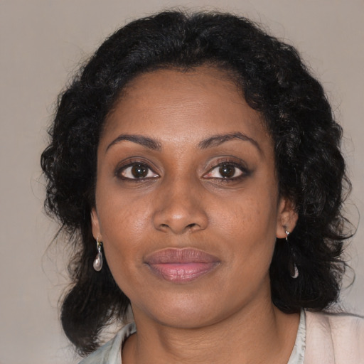 Joyful black adult female with medium  brown hair and brown eyes