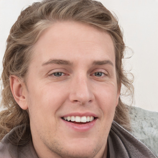 Joyful white young-adult male with medium  brown hair and blue eyes