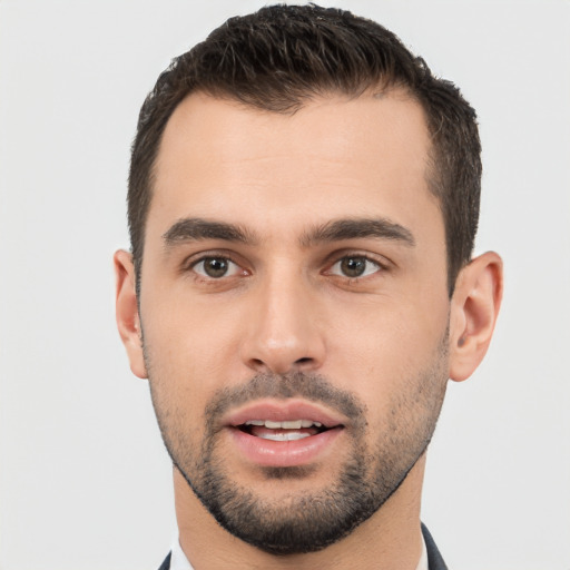 Joyful white young-adult male with short  black hair and brown eyes