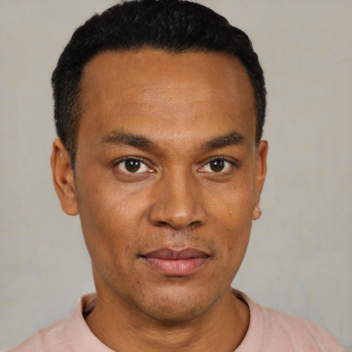 Joyful black young-adult male with short  black hair and brown eyes