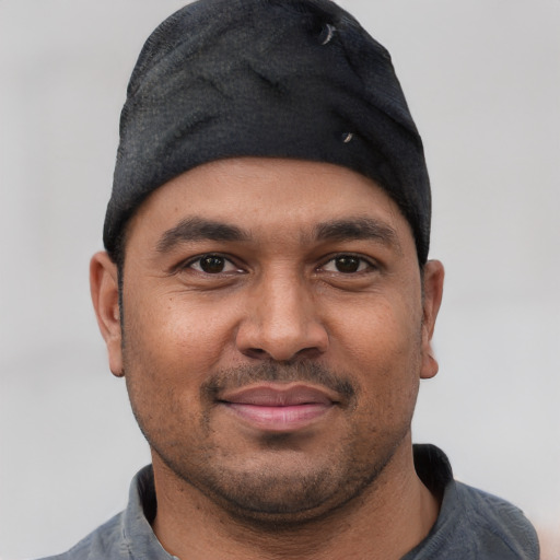 Joyful black young-adult male with short  black hair and brown eyes