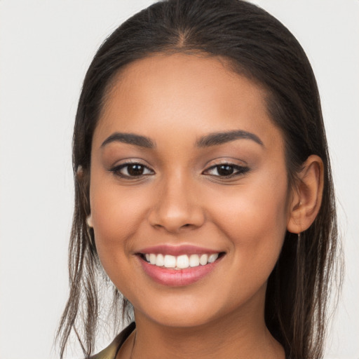 Joyful latino young-adult female with long  brown hair and brown eyes