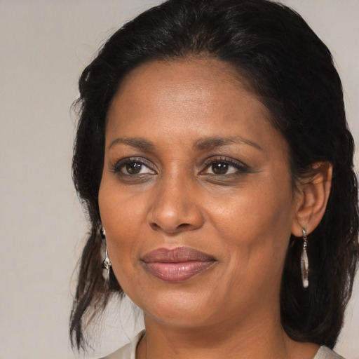 Joyful black adult female with medium  brown hair and brown eyes