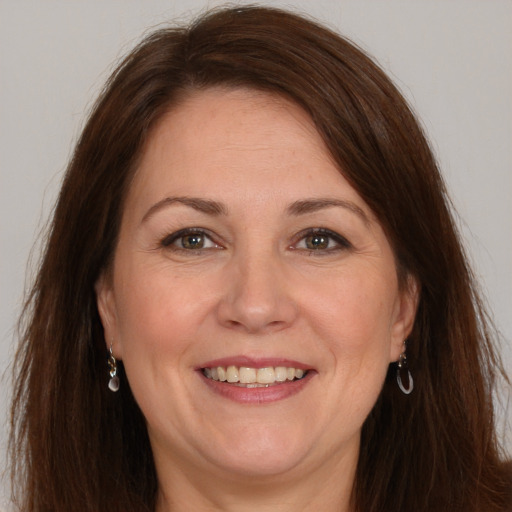 Joyful white adult female with long  brown hair and brown eyes