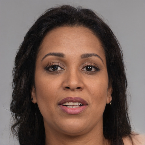 Joyful latino adult female with long  brown hair and brown eyes