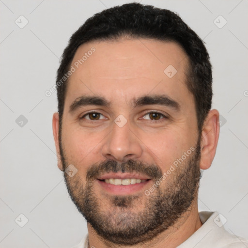 Joyful white young-adult male with short  black hair and brown eyes