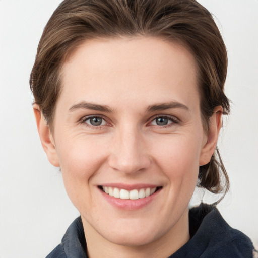 Joyful white young-adult female with medium  brown hair and grey eyes