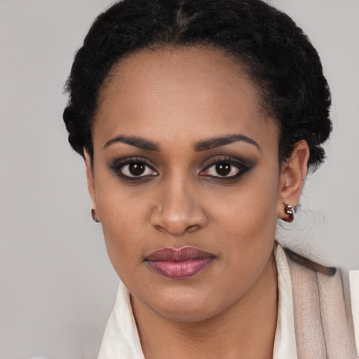 Joyful black young-adult female with short  black hair and brown eyes