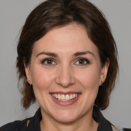 Joyful white adult female with medium  brown hair and brown eyes