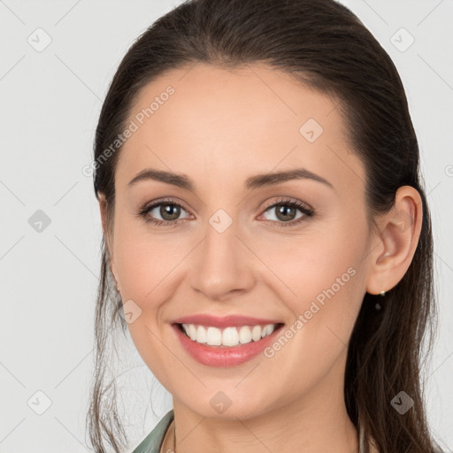 Joyful white young-adult female with long  brown hair and brown eyes