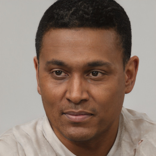 Joyful black young-adult male with short  black hair and brown eyes