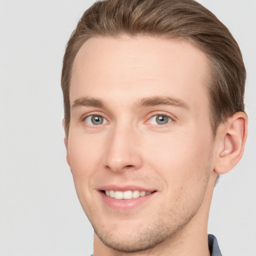 Joyful white young-adult male with short  brown hair and grey eyes