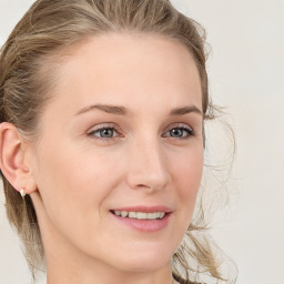 Joyful white young-adult female with medium  brown hair and blue eyes