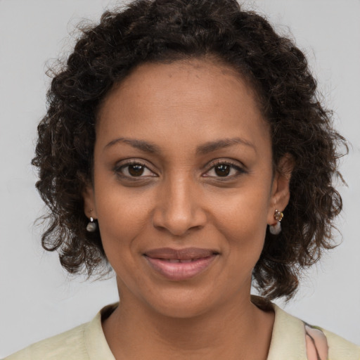 Joyful black young-adult female with medium  brown hair and brown eyes