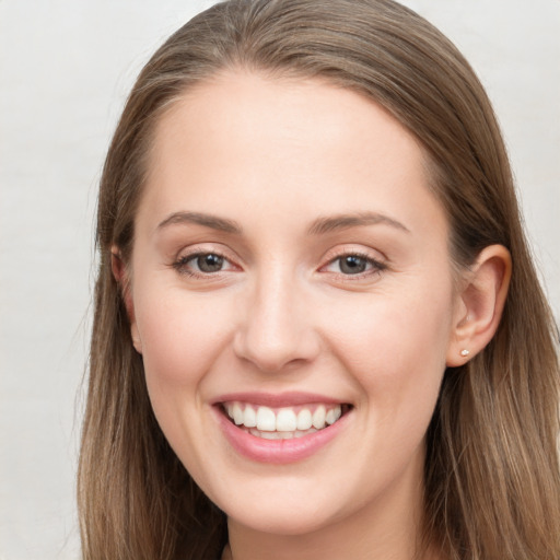 Joyful white young-adult female with long  brown hair and grey eyes