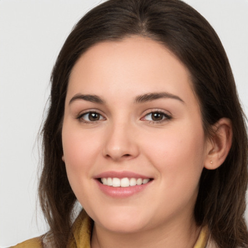 Joyful white young-adult female with long  brown hair and brown eyes