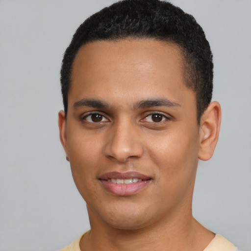 Joyful latino young-adult male with short  black hair and brown eyes