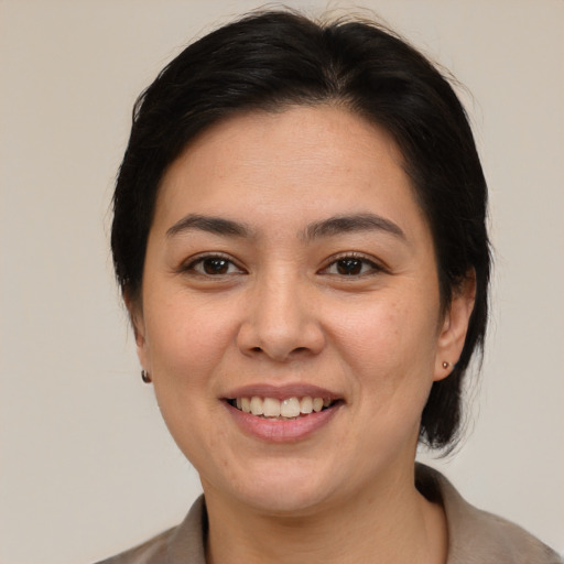 Joyful asian young-adult female with medium  brown hair and brown eyes