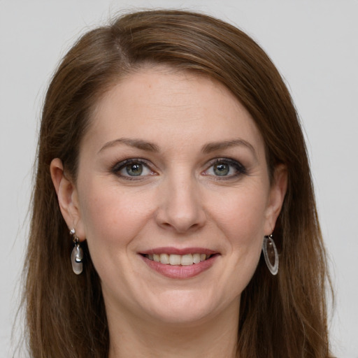 Joyful white young-adult female with long  brown hair and grey eyes