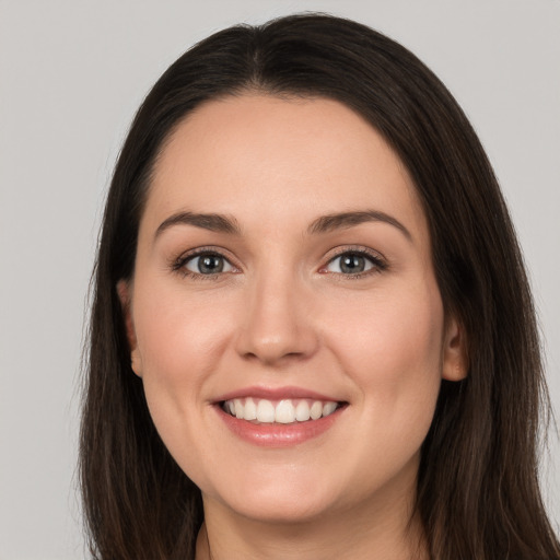 Joyful white young-adult female with long  brown hair and brown eyes