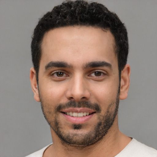 Joyful white young-adult male with short  black hair and brown eyes