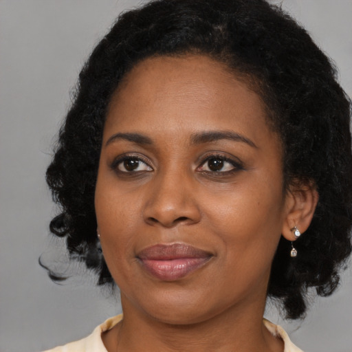 Joyful black young-adult female with medium  black hair and brown eyes