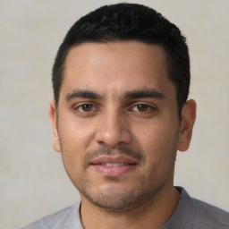 Joyful latino young-adult male with short  black hair and brown eyes