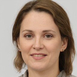 Joyful white adult female with medium  brown hair and grey eyes