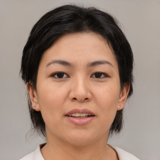 Joyful asian adult female with medium  brown hair and brown eyes