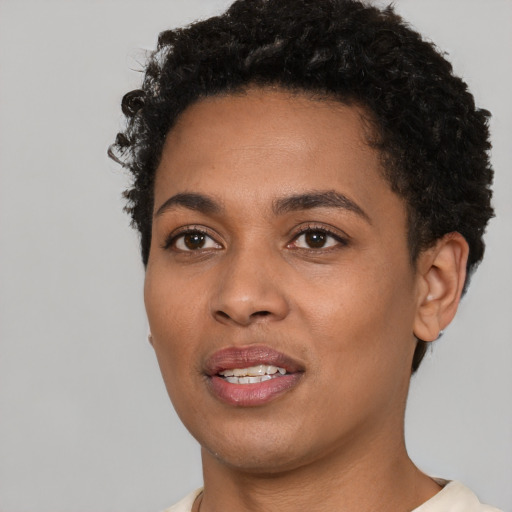 Joyful black young-adult female with short  black hair and brown eyes