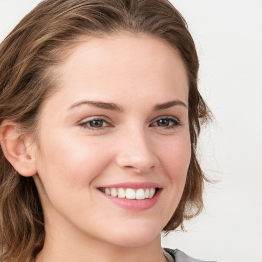 Joyful white young-adult female with long  brown hair and blue eyes