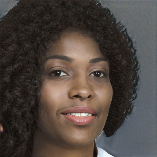 Joyful black young-adult female with long  brown hair and brown eyes