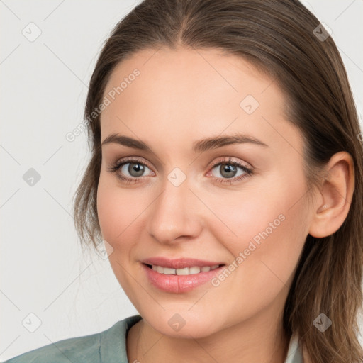 Joyful white young-adult female with long  brown hair and blue eyes