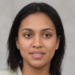 Joyful latino young-adult female with long  brown hair and brown eyes