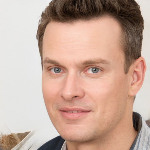 Joyful white adult male with short  brown hair and grey eyes