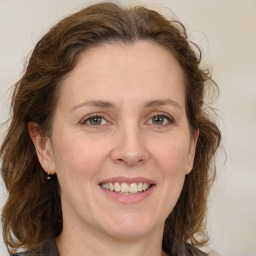 Joyful white adult female with medium  brown hair and green eyes